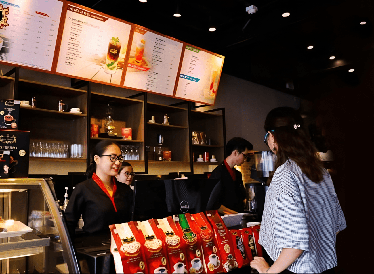 Nhân viên King Coffee đón tiếp khách hàng bên quầy trưng bày cà phê tại điểm bán